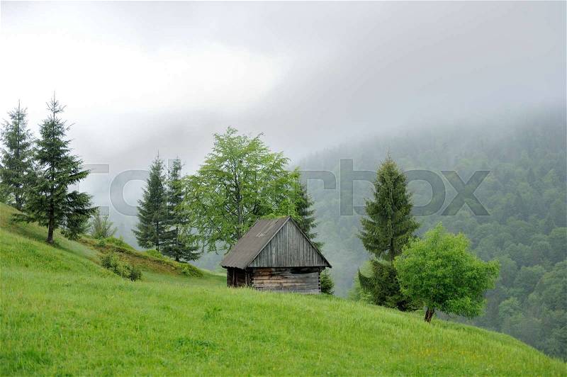 An old house and fog in mountain. Summer day, stock photo
