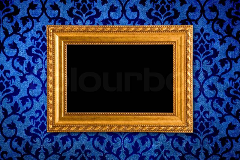 Gold frame on a vintage blue wall background, stock photo