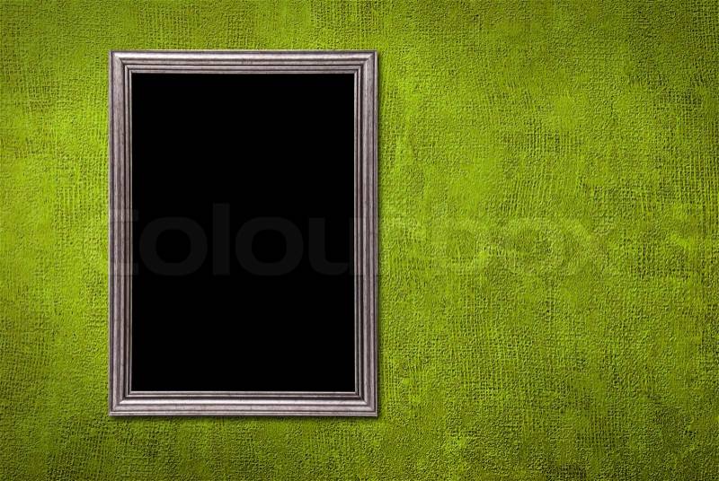 Silver frame on a green wall background, stock photo