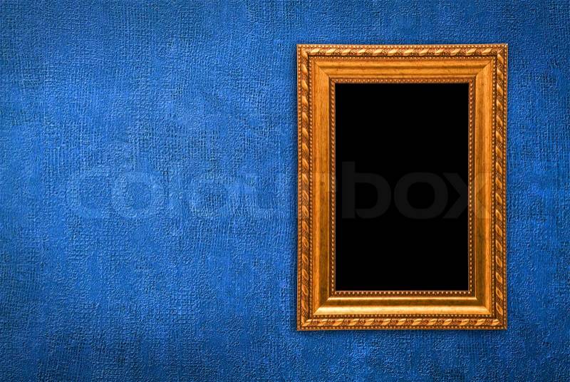 Gold frame on a old blue wall background, stock photo