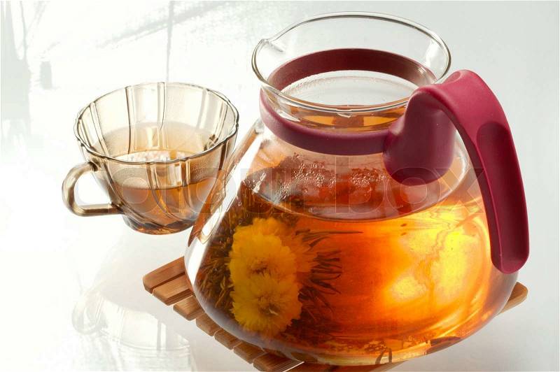 Hot flower tea in a transparent teapot, stock photo