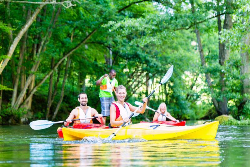 Friends paddling with canoe on forest river, stock photo