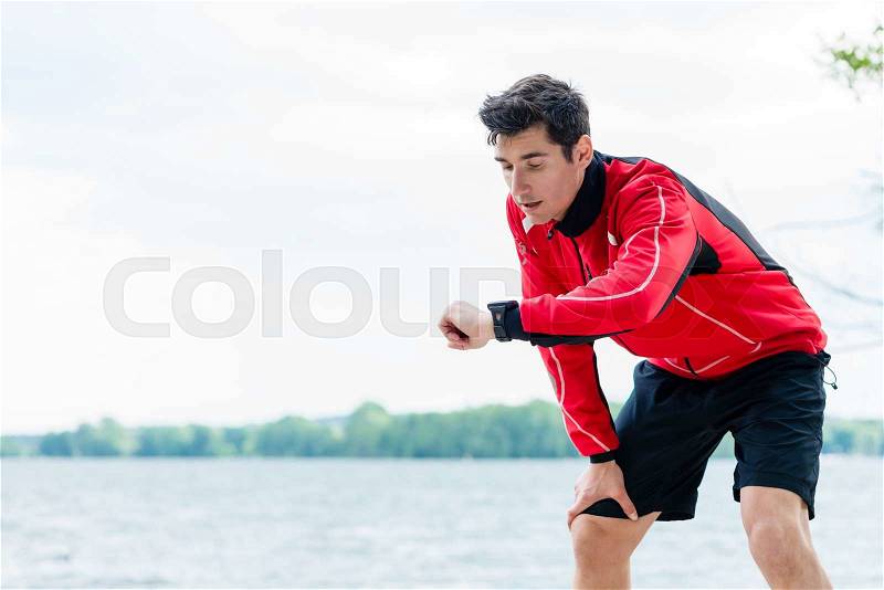 Woman and man at break from running in front of lake, stock photo