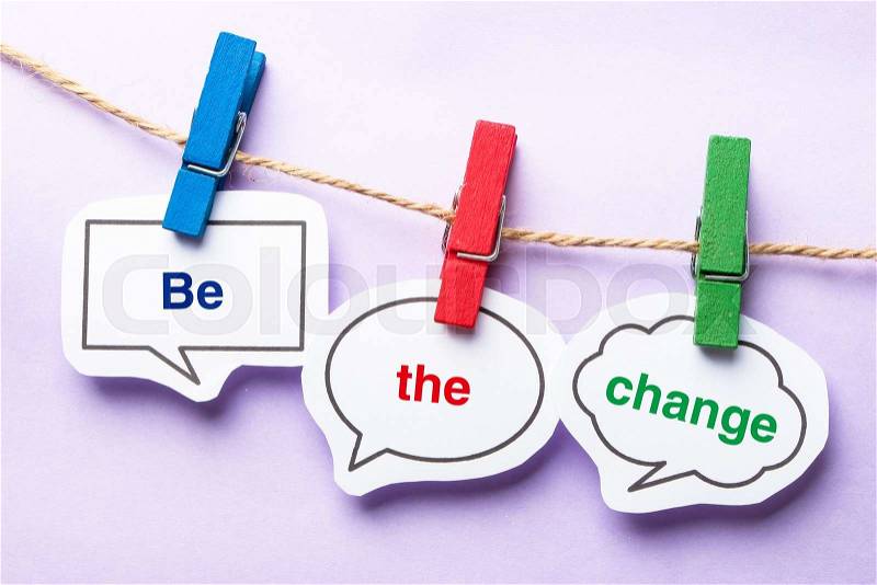 Be the change paper bubbles with clip hanging on the line against purple background, stock photo