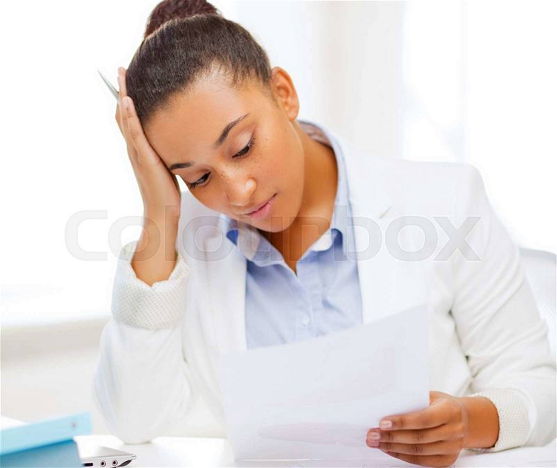 Business and tax concept - african businesswoman working with calculator in office, stock photo