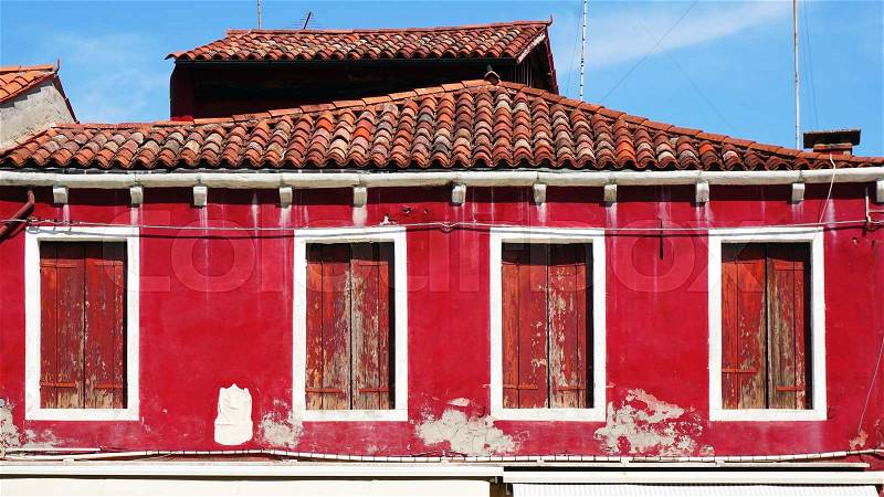 Old window house and roof with red color wall architecture in Murano, Venice, Italy, stock photo