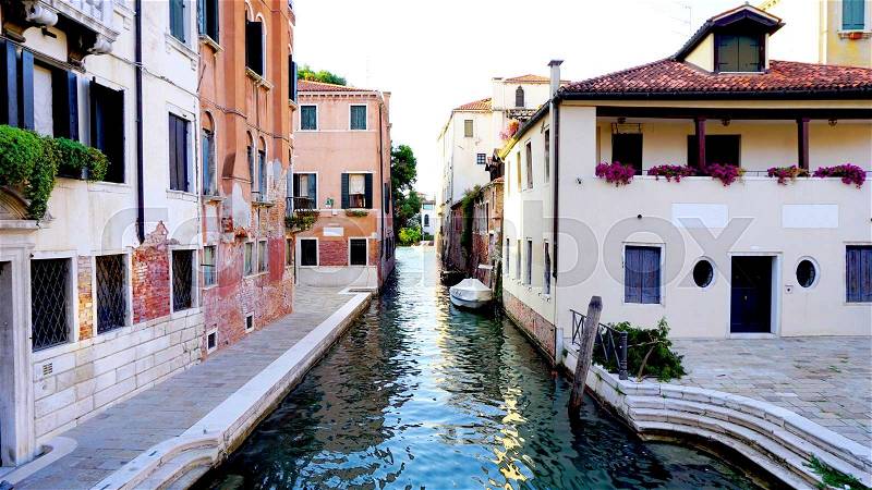 Alley with ancient architecture and canal in Venice, Italy, stock photo