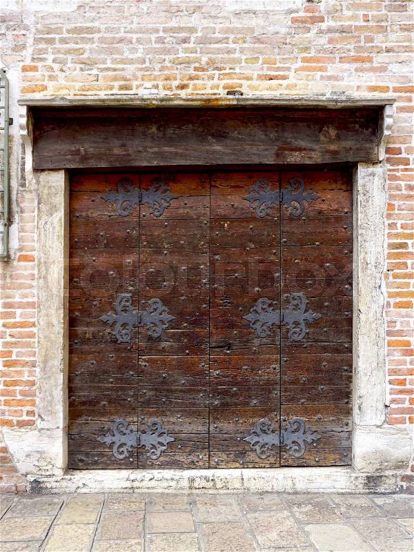 Close up wooden door with brick wall building architecture in Venice, Italy, stock photo