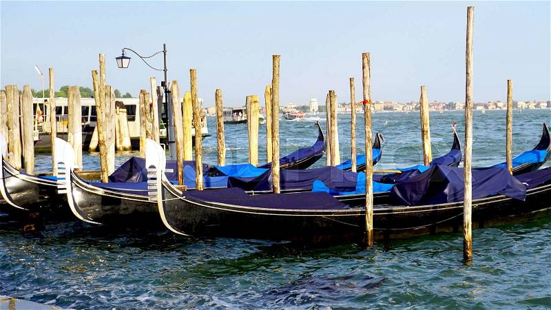 Gondola boats floating in the sea in Venice, Italy, stock photo