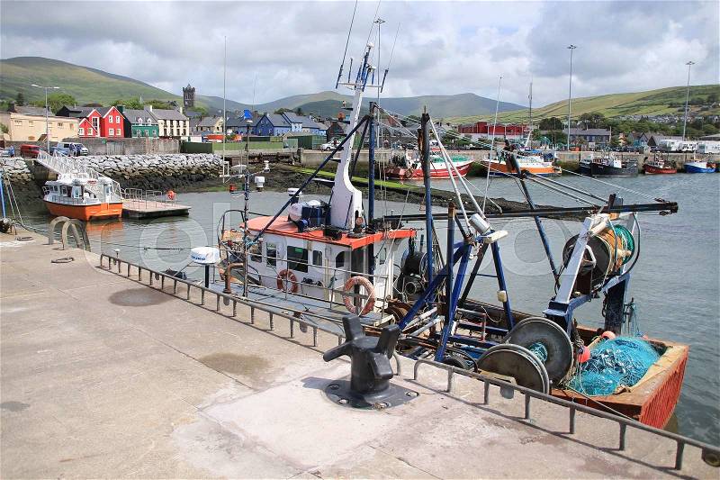The harbour with fishing boats and at the background the striking painted houses in the village Dingle in Ireland in the summer, stock photo