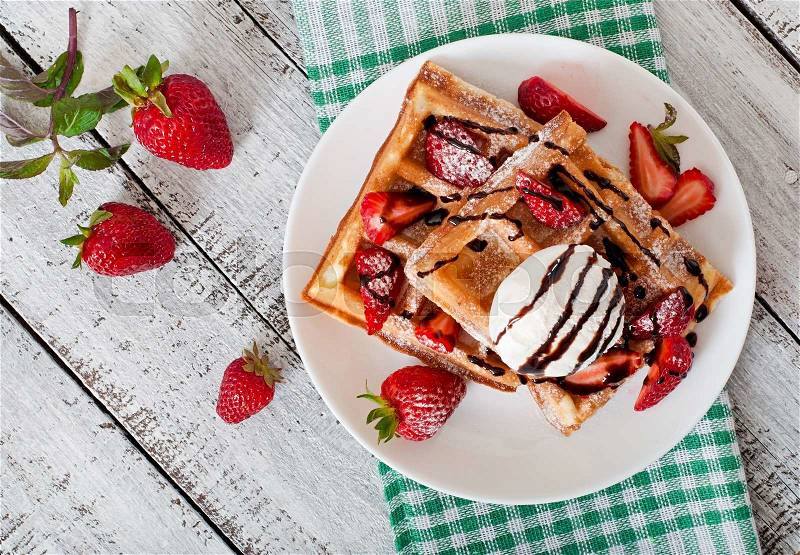 Belgium waffles with strawberries and ice cream on white plate, stock photo