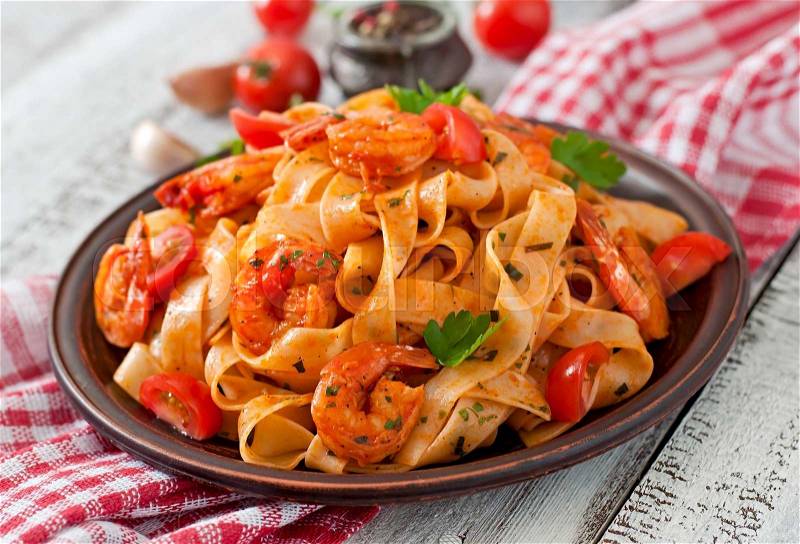 Fettuccine pasta with shrimp, tomatoes and herbs, stock photo