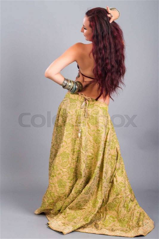 Beautiful girl belly dance movement, Young beautiful belly dancer in a golden costume, stock photo
