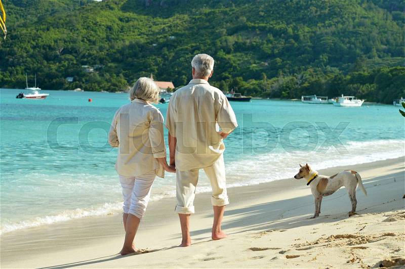 Beautiful happy elderly couple rest at tropical resort with dog, stock photo