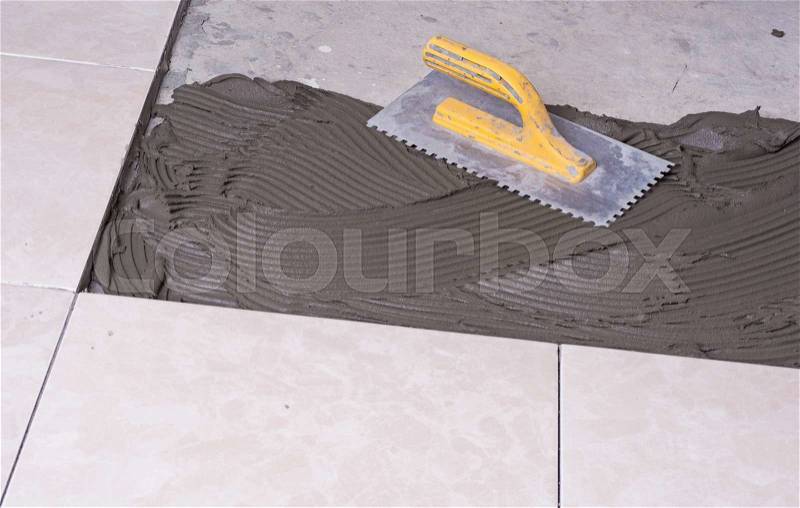 Notched trowel, spacers and prepared setting compound for tile, stock photo