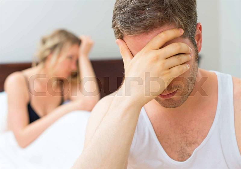 Upset young couple having problems with sex, stock photo