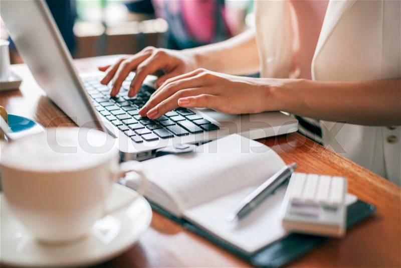 Journalist typing document in a coffee shop, stock photo