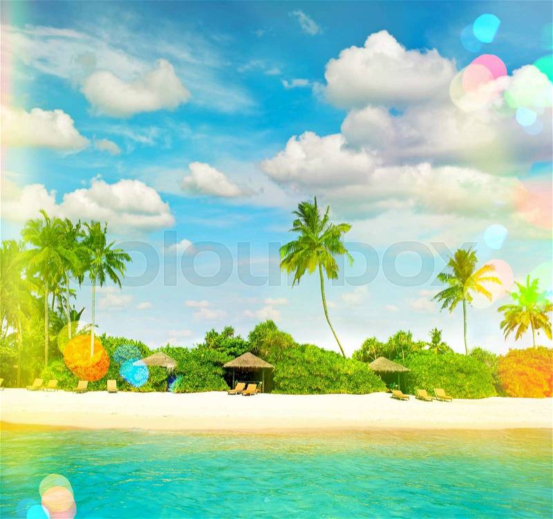 Tropical island sand beach with palm trees and cloudy blue sky. Retro style toned picture with light leaks, stock photo