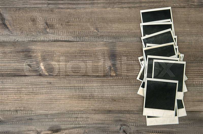 Old instant photo frames on rustic wooden background. Retro style toned picture, stock photo