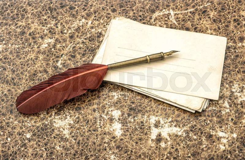 Antique feather pen and paper sheets. Retro style toned picture, stock photo