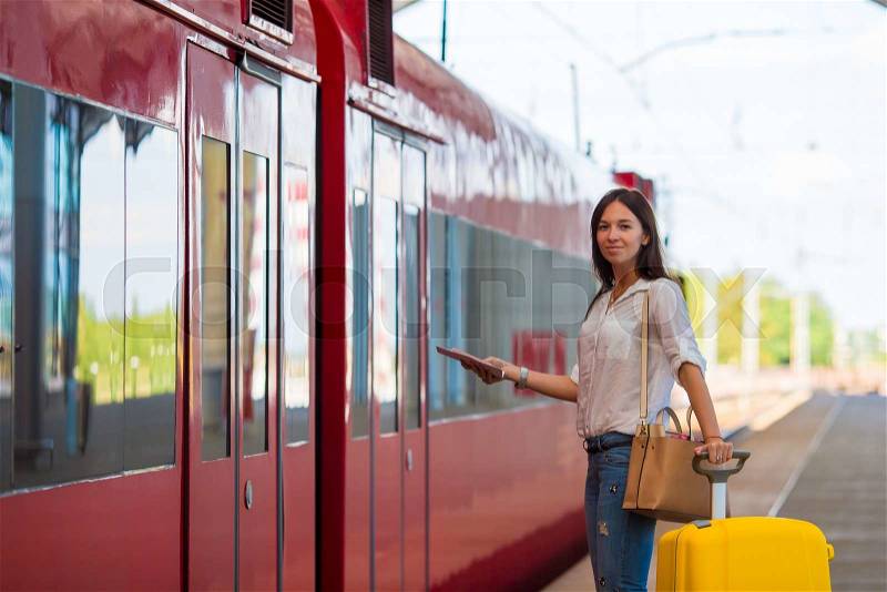 Young woman with luggage on the platform waiting for aeroexpress, stock photo