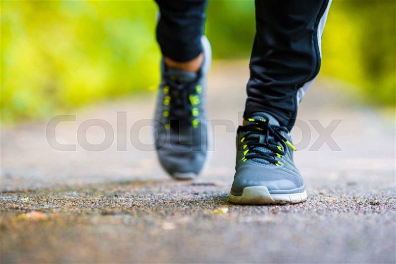 Close-up on shoe of athlete runner man feet running on road, stock photo