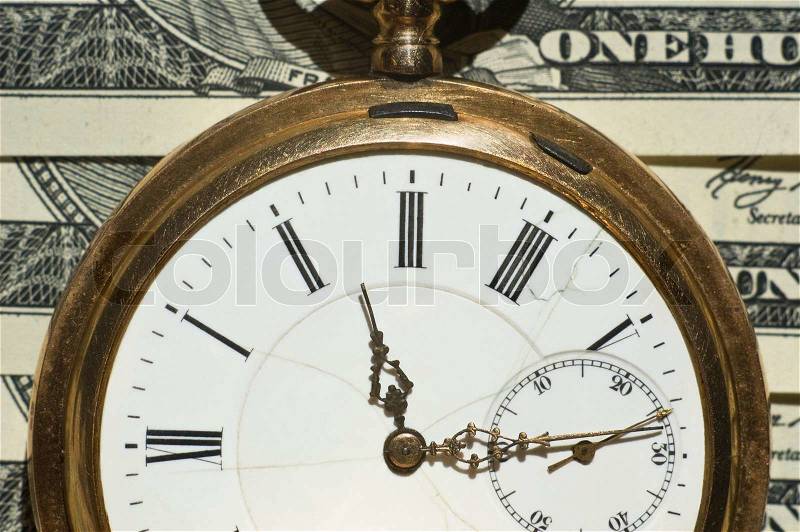 Time and Money concept image.Shallow DOF us currency and a pocket watch portray time and money, stock photo