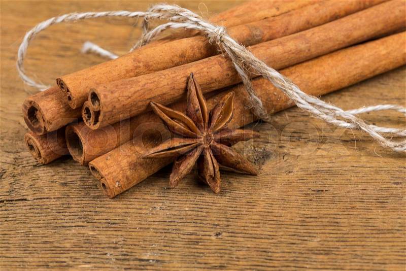 Close up of cinnamon sticks and star anise on rustic wood background, stock photo
