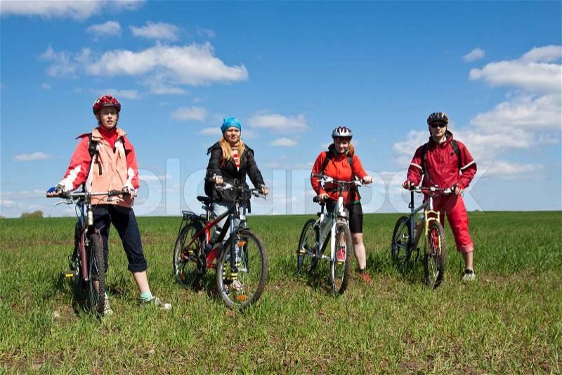 A group of four adults on bicycles in the countryside. Everyone can ride a bike. Everyone who rides a bike is my friend, stock photo