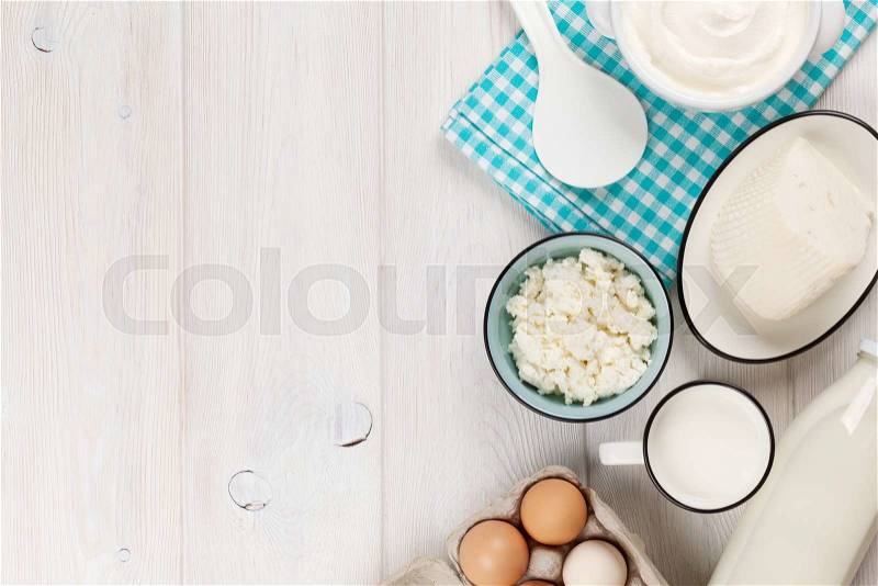 Dairy products on wooden table. Sour cream, milk, cheese, eggs and yogurt. Top view with copy space, stock photo
