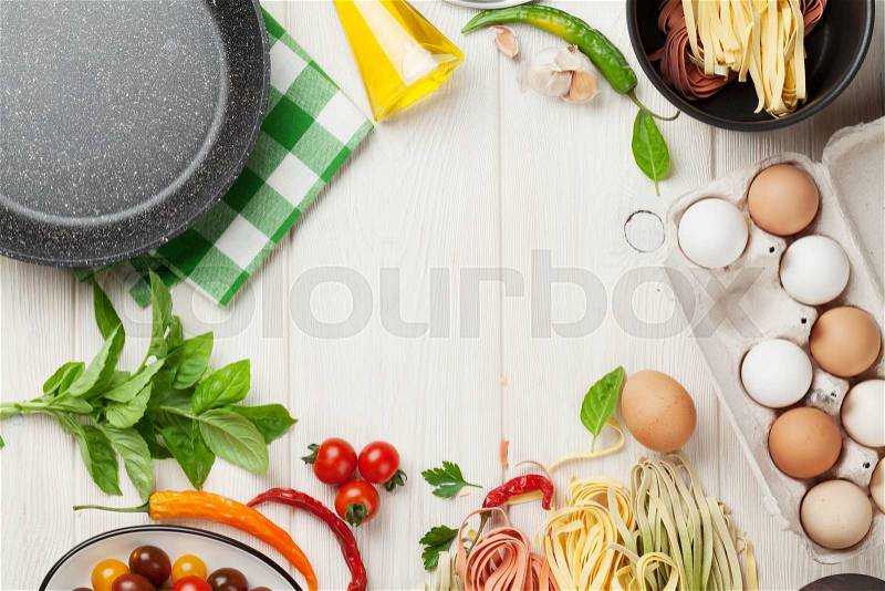 Pasta cooking ingredients and utensils on wooden table. Top view with copy space, stock photo
