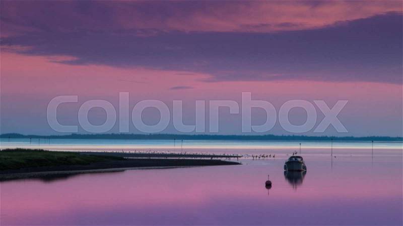 Beautiful pink and purple ocean sunset on a peaceful summer evening at the beach on the danish west coast, stock photo