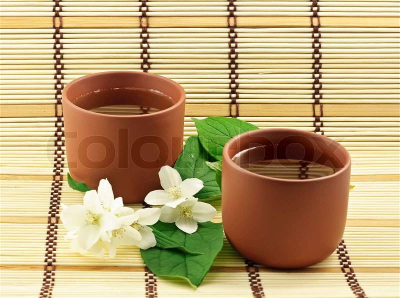 Two clay cups with jasmin green tea, stock photo