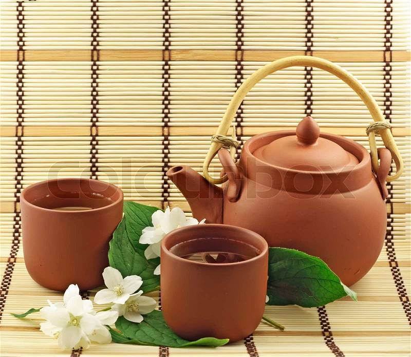 Clay set with green tea and jasmin flowers, stock photo