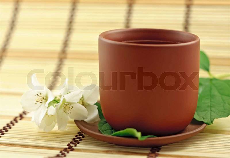 Clay cup with green tea and jasmin flowers, stock photo