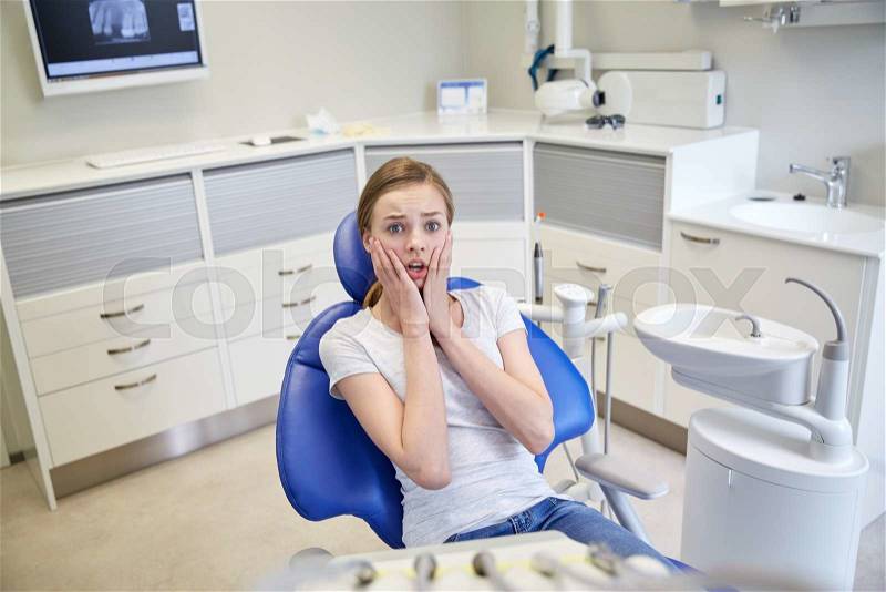 People, medicine, stomatology and phobia concept - scared and terrified patient girl at dental clinic office, stock photo