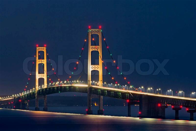 Colorful lights decorate the Mackinaw Bridge, a long suspension bridge and engineering marvel crossing the Straits of Mackinac and connecting Michigan\'s Upper and Lower Peninsulas, stock photo
