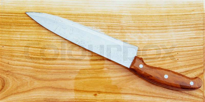 Knife on an wooden cutting board, stock photo