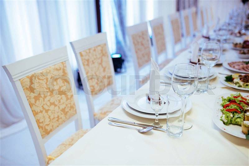 Formal stylish setting on a dinner table with elegant glassware and linen for a party or celebration of a special event, stock photo