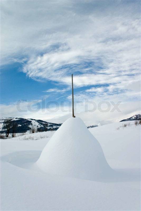 Rick of straw covered with snow on the white snowy plain, stock photo