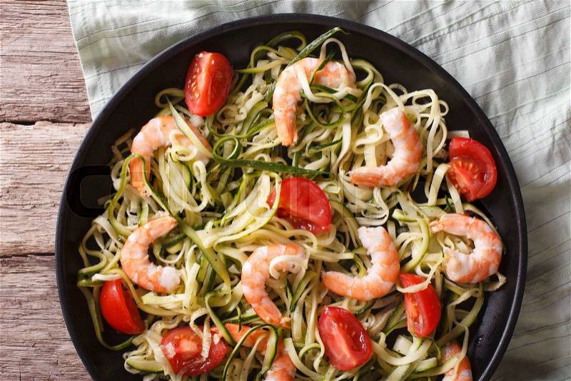 Dietary food: zucchini pasta with shrimp and tomato on a plate close-up. horizontal view from above , stock photo