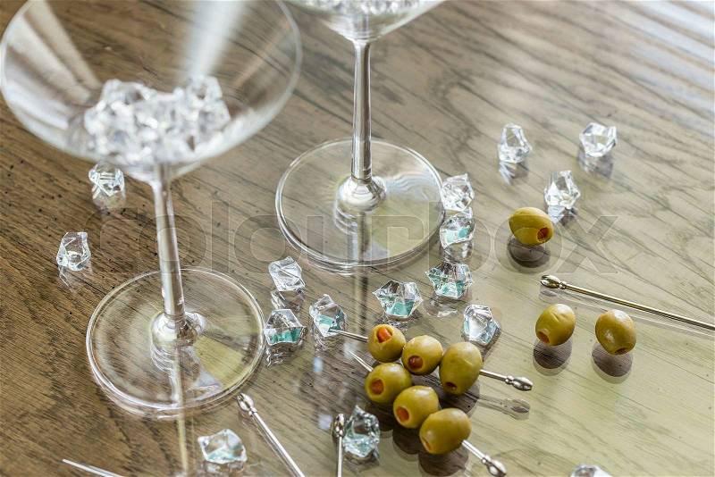 Two martini glasses with olives on martini picks, stock photo