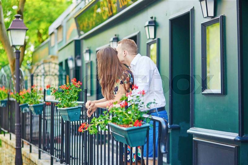 Romantic couple on the balcony decorated with flowers on Montmartre, Paris, stock photo