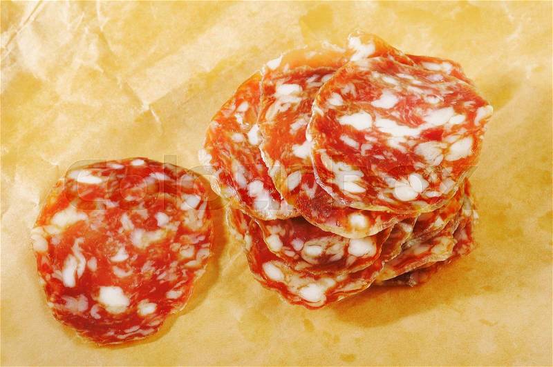 Sliced salami on brown paper, stock photo