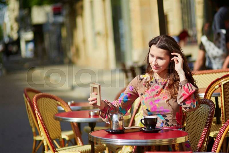 Beautiful young woman in a Parisian street cafe, enjoying sunny week-end, stock photo