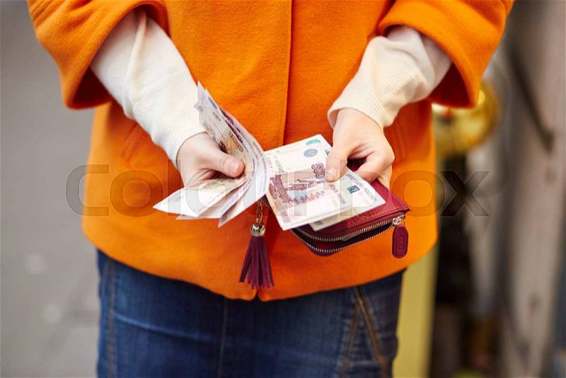 Woman hands holding purse with Russian roubles, financial crisis in Russia concept, stock photo