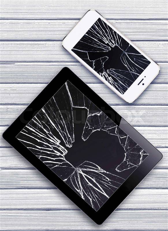 Modern mobile phone and Black Touch Screen Tablet with broken screen on white wooden background, stock photo