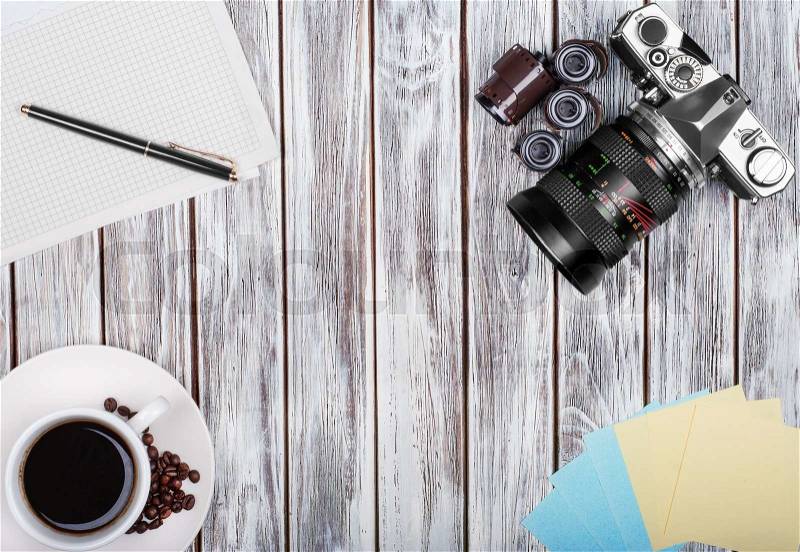 Vintage camera, diary with pan and cup pf coffee on wooden table, stock photo