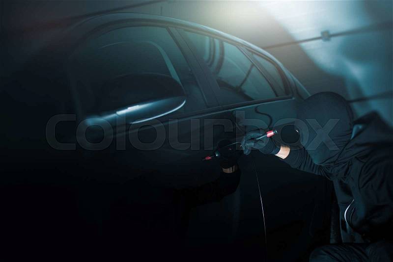 Dark Place Car Robbery. Car Robber Working to Open Cars Door. , stock photo