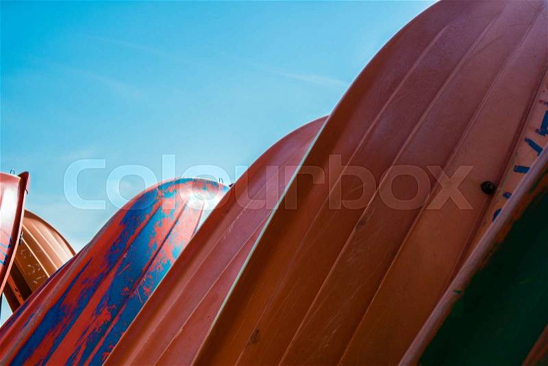 Several plastic colored boats on land, stock photo